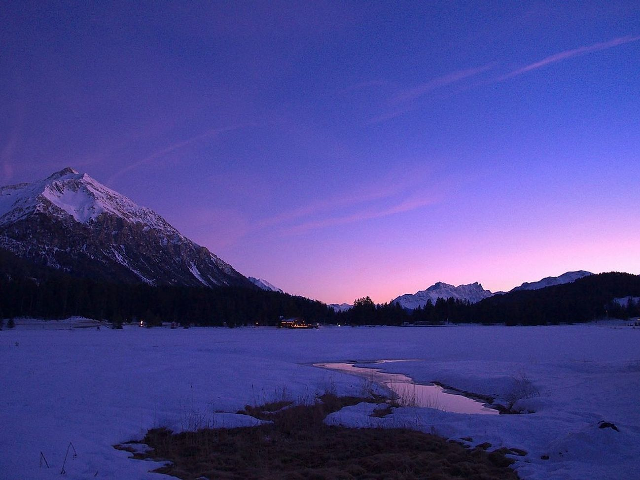 Terra aperta sopra gli ultimi alberi, prima del lago tra le montagne